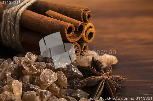 Image of Cinnamon sticks with pure cane brown sugar on wood background