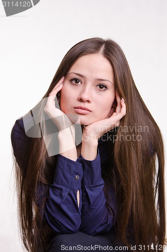Image of Beautiful girl rests her chin on hand