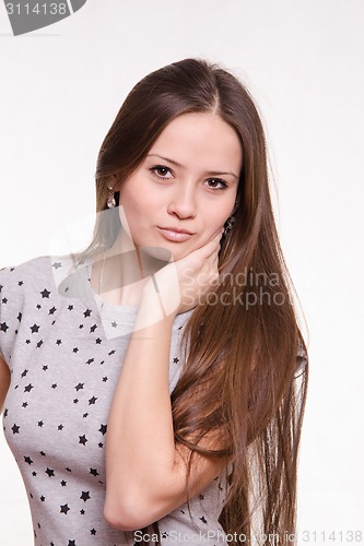 Image of Beautiful girl with long hair holds a hand on the neck