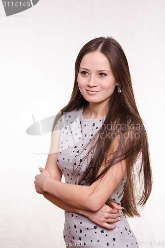 Image of Girl hugging her arms gazing into the distance