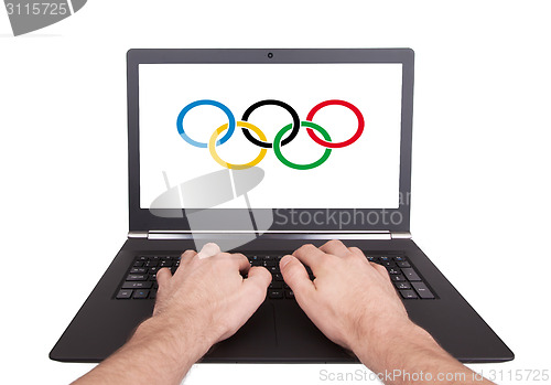 Image of Man working on laptop, olympic rings