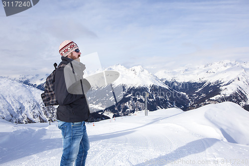 Image of Young man enjoys the view in the mountains
