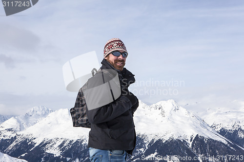 Image of Young man enjoys the view in the mountains