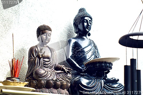 Image of two buddhas on shelf with incense