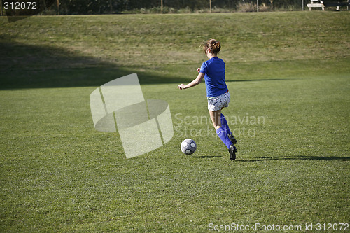 Image of Girl Dribbling a Soccer Ball Before a Match