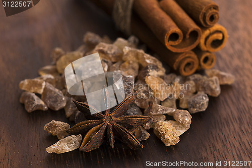 Image of Cinnamon sticks with pure cane brown sugar on wood background