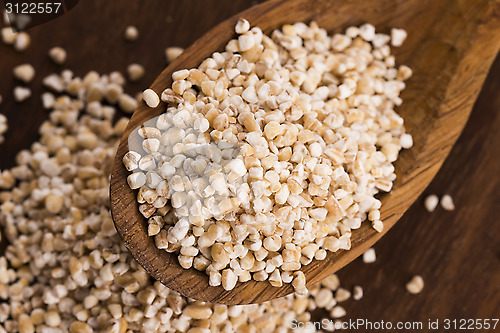 Image of Barley groats on wooden spoon