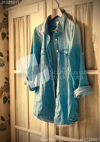 Image of denim shirt on a hanger