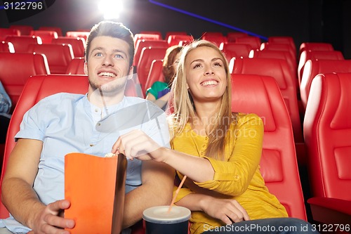 Image of happy friends watching movie in theater