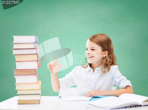 Image of happy girl with books and notebook at school