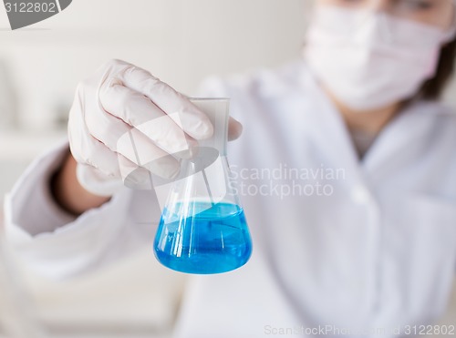 Image of close up of woman with flask making test in lab