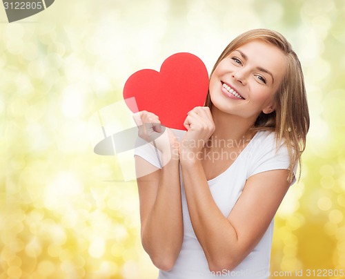 Image of smiling woman in white t-shirt holding red heart