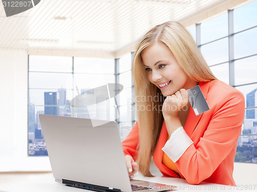 Image of smiling woman with laptop computer and credit card