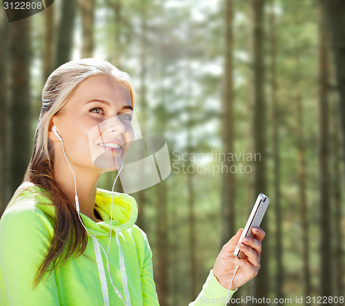 Image of happy woman with smartphone and earphones