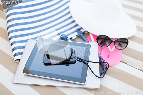 Image of close up of tablet pc and smartphone on beach
