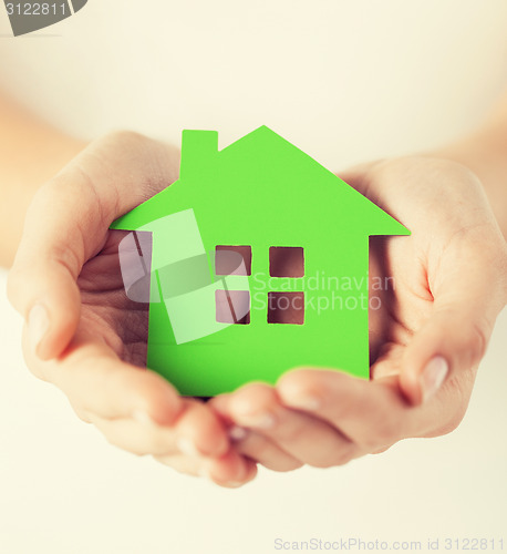 Image of woman hands holding green house