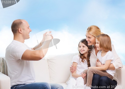 Image of happy family with camera at home