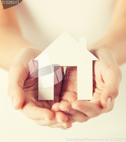 Image of woman hands holding paper house