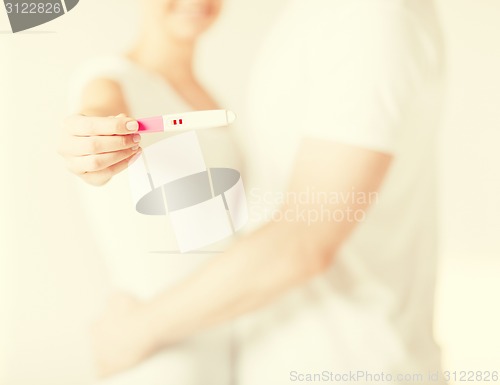 Image of woman and man hands with pregnancy test