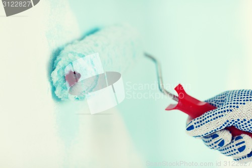 Image of close up of male in gloves painting wall