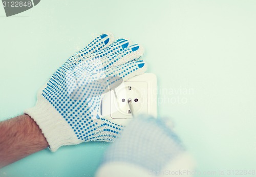 Image of close up of male in gloves installing new socket