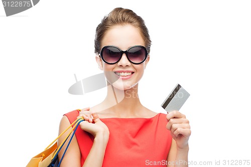 Image of smiling woman with shopping bags and plastic card