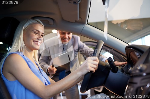 Image of happy woman with car dealer in auto show or salon