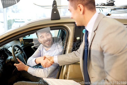 Image of happy man with car dealer in auto show or salon