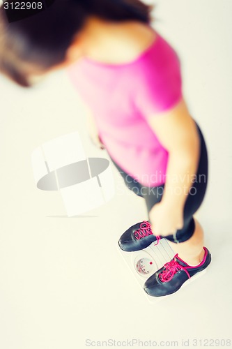 Image of woman legs standing on scales