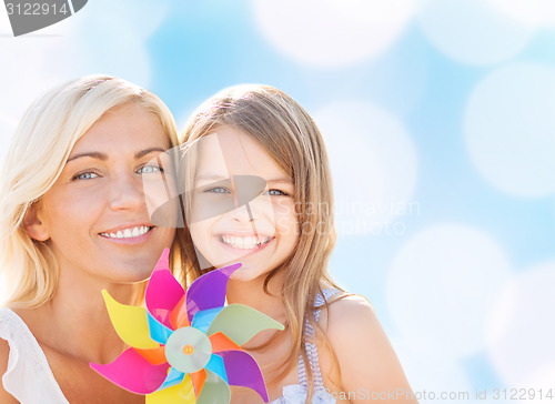 Image of happy mother and little girl with pinwheel toy