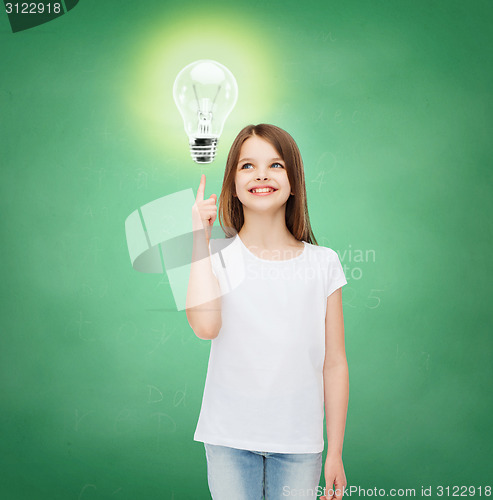 Image of smiling school girl pointing finger to light bulb