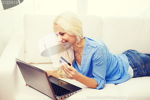 Image of smiling woman with laptop computer and credit card