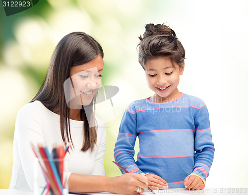 Image of happy mother and daughter drawing with pencils