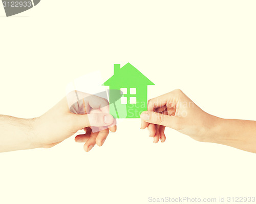 Image of couple hands holding green house