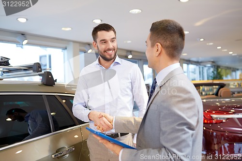 Image of happy man shaking hands in auto show or salon