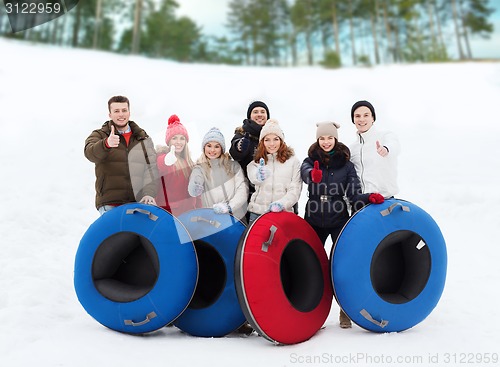 Image of group of smiling friends with snow tubes