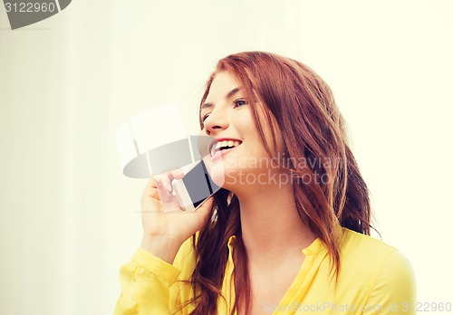 Image of smiling teenage girl with smartphone at home