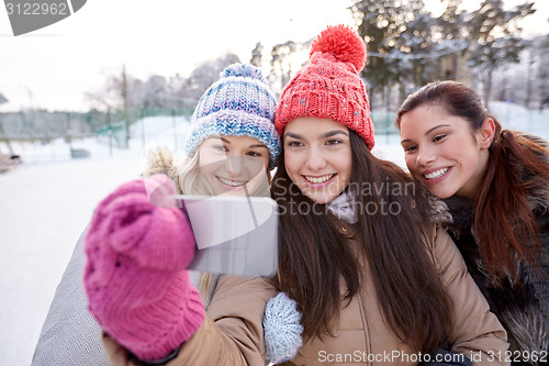 Image of happy teenage girls taking selfie with smartphone