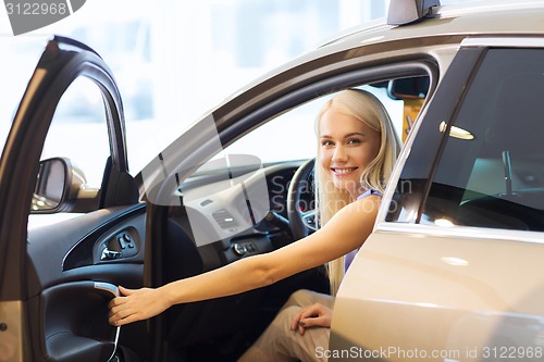 Image of happy woman inside car in auto show or salon