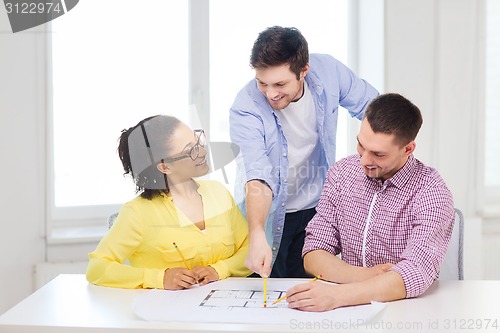 Image of three smiling architects working in office
