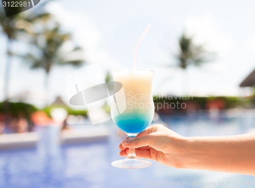 Image of close-up of hand holding glass with cocktail