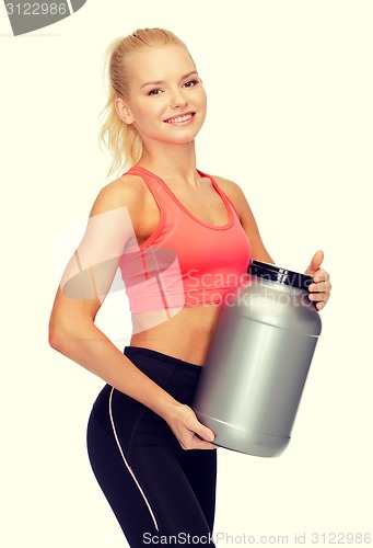 Image of smiling sporty woman with jar of protein