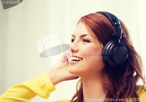 Image of smiling young girl in headphones at home