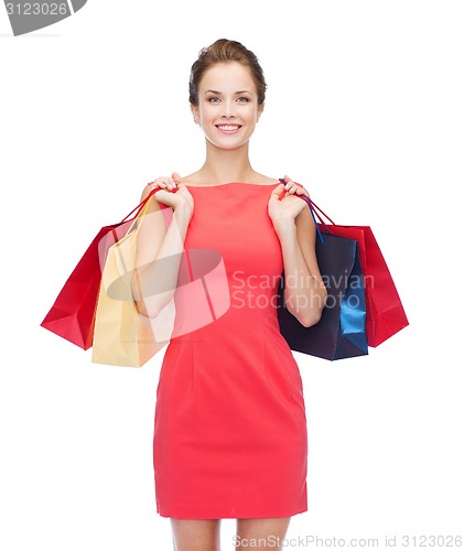 Image of smiling elegant woman in dress with shopping bags