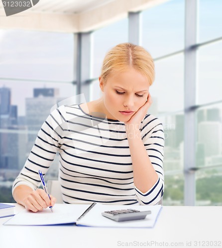 Image of young woman with notebook and calculator