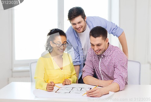 Image of three smiling architects working in office