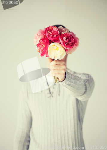 Image of man covering his face with bouquet of flowers