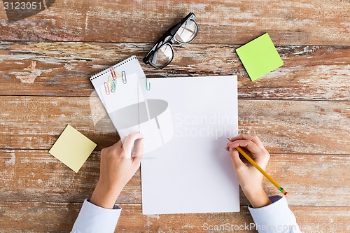 Image of close up of hands with papers and eyeglasses