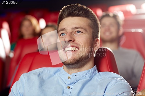 Image of happy young man watching movie in theater
