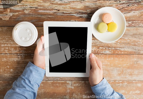 Image of close up of male hands with tablet pc and coffee